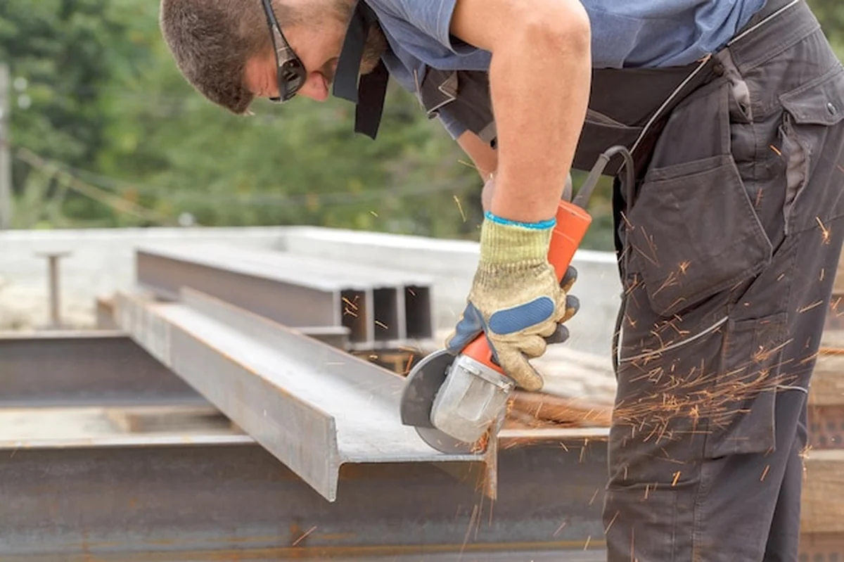 Pracownik tnie metalowy produkt elektrycznym flexem