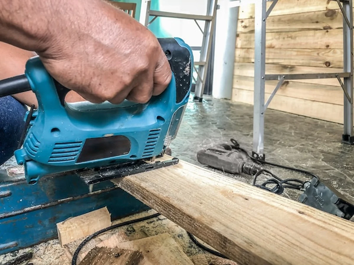 Stolarz piłuje drewno do ścian i dekoracji w domu klienta