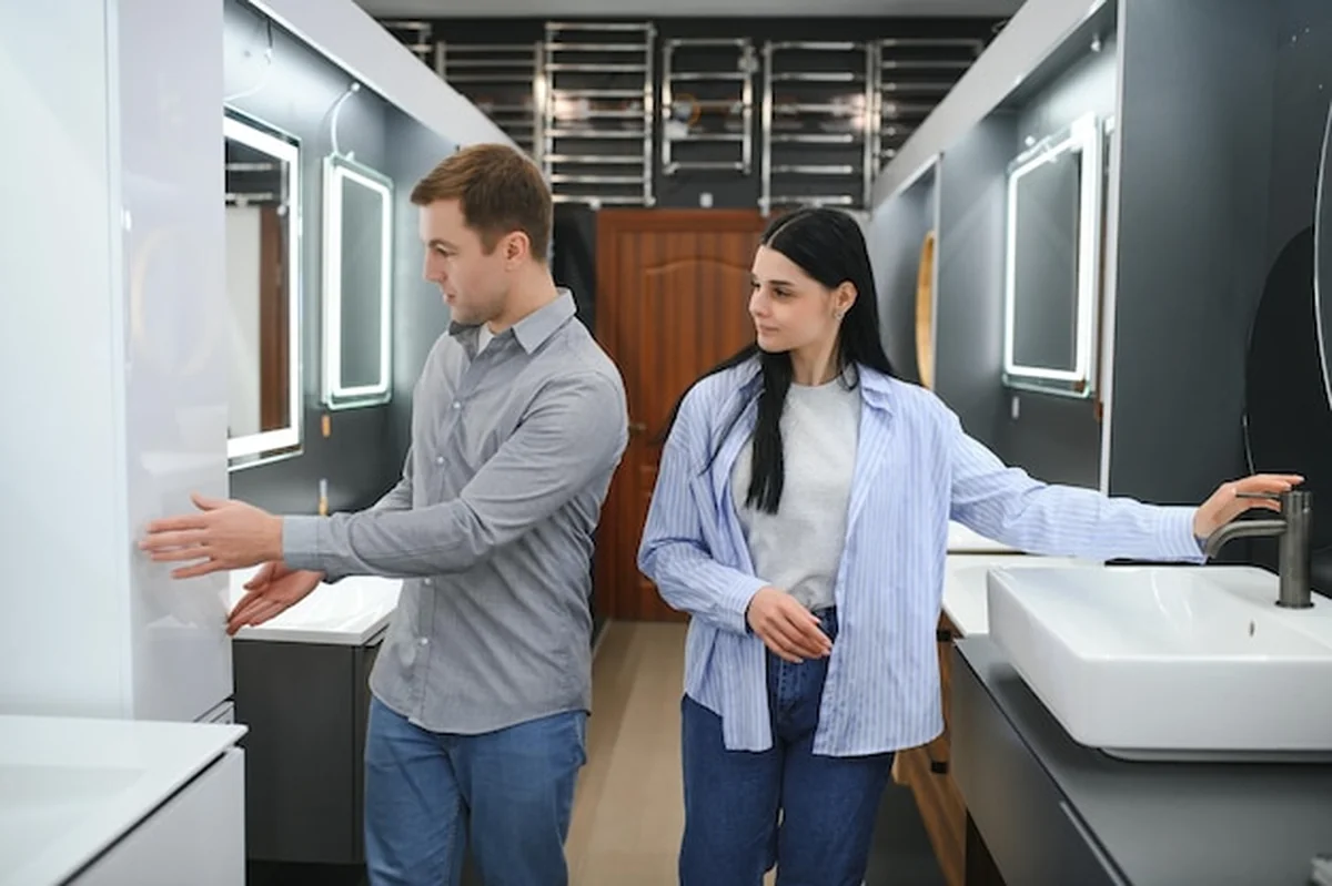 Młoda para wybiera nowe meble łazienkowe w sklepie hydraulicznym z artykułami sanitarnymi