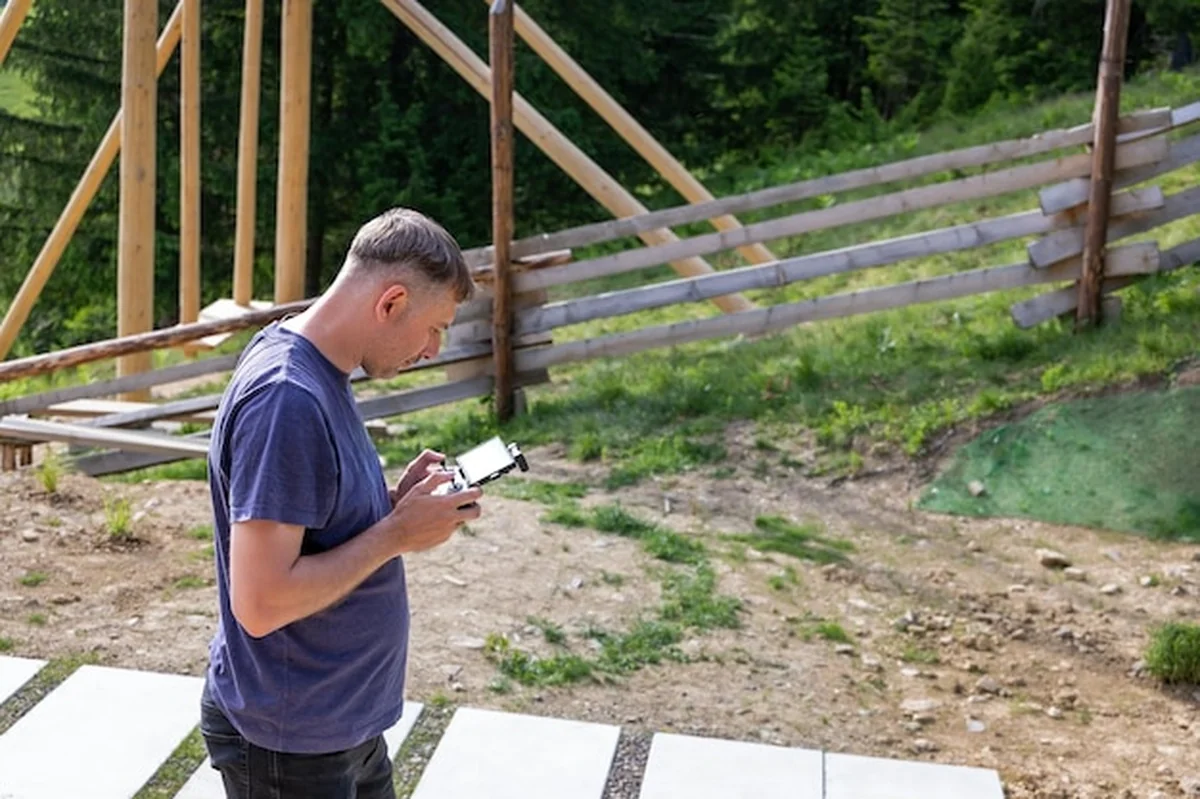 Mężczyzna obsługujący drona na wsi