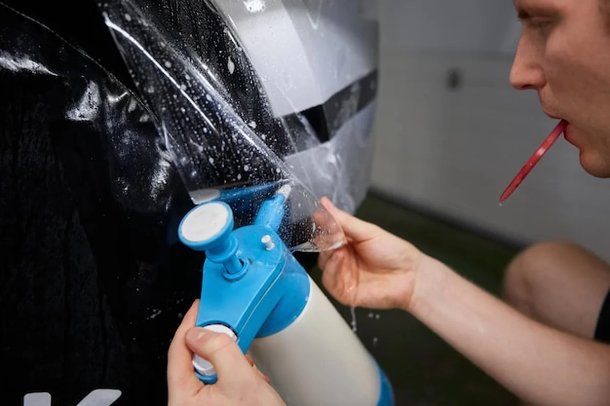 Pracownik wygładza folię winylową w garażu