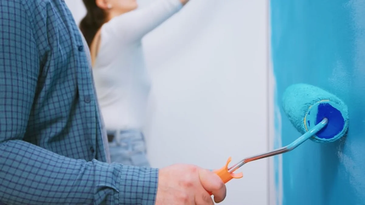 Para maluje ściany podczas remontu domu