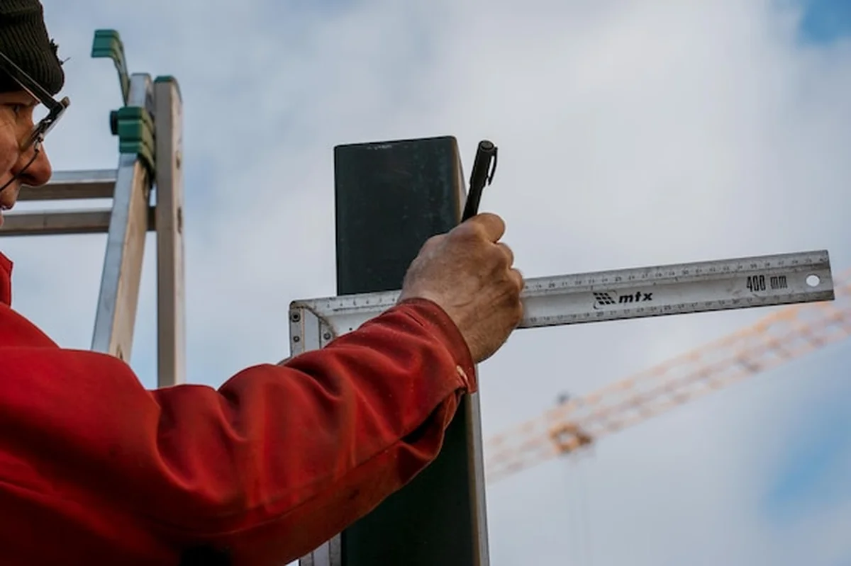 Robotnik mierzący i wyznaczający linię na rurze