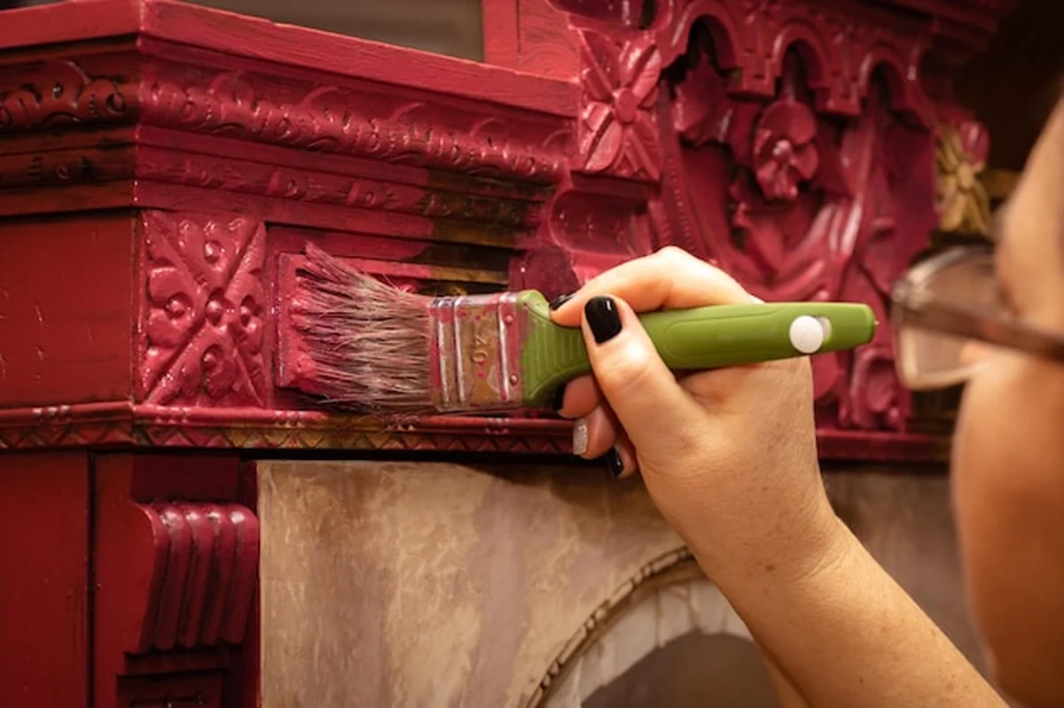 Stara drewniana szafka pomalowana na różowo dużym pędzlem