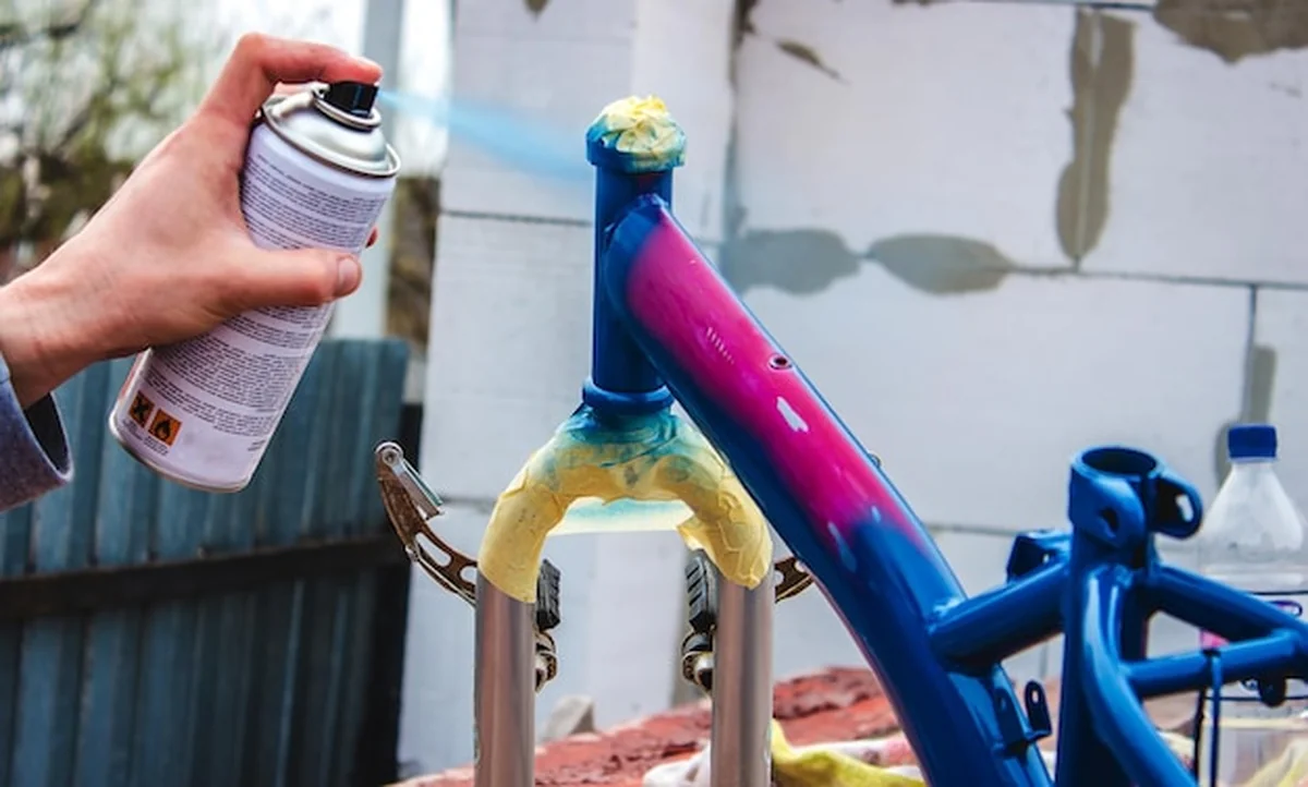 Mężczyzna maluje rower farbą w sprayu