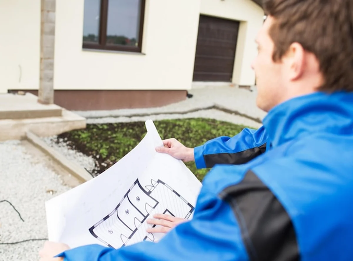 Budowniczy z projektem domu na zewnątrz