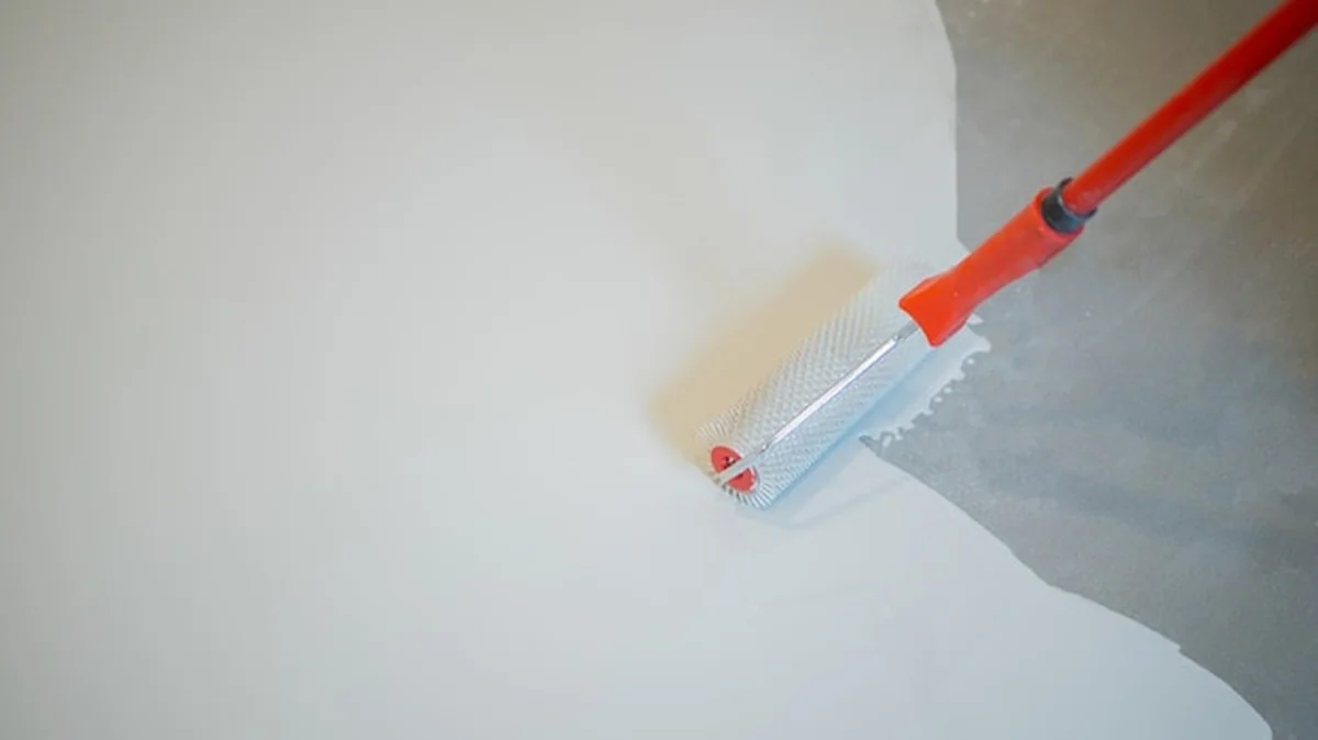 Pracownik budowlany gipsujący ścianę za pomocą trowela