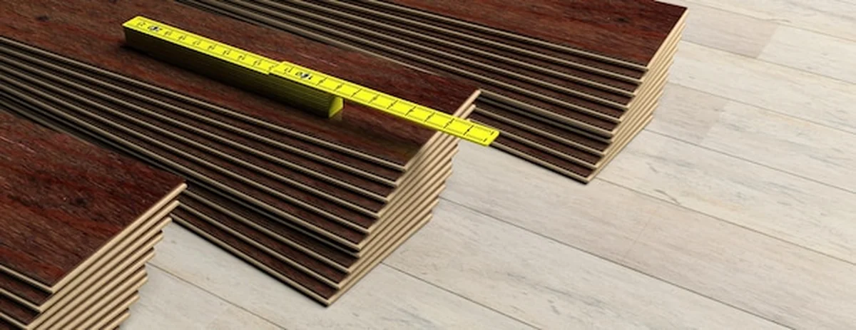 Żółty drewniany metr na laminowanych panelach podłogowych